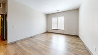 Located at 9938 Transition Cir in Lone Tree, CO, this well-designed 2-bedroom, 3-bathroom residence offers a thoughtfully laid-out single-floor plan with a clean, modern aesthetic throughout. Warm wood-look flooring runs continuously across all rooms, complemented by neutral-toned walls and sleek gray interior doors with paneled detailing.

The open-concept kitchen and living area serves as the heart of the home. The kitchen is outfitted with light wood cabinetry extending to the ceiling for ample storage, stainless steel appliances including a refrigerator, range, microwave, and dishwasher, and a crisp white quartz countertop island that provides additional workspace and casual seating. Track lighting overhead enhances functionality in this central gathering space.

The primary bedroom is a comfortable retreat with its own dedicated closet and access to a well-appointed en-suite bathroom featuring a glass-enclosed walk-in shower with white subway tile, a dual-sink vanity with light wood cabinetry and quartz countertop, and a separate water closet. Two additional full bathrooms serve the second bedroom and guests. The second bedroom is generously sized, featuring a ceiling fan and natural light from a window with blinds. Two closets provide practical storage throughout the residence.