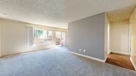 Located at 1175 W Blaine St in Riverside, California, this single-floor residence offers four bedrooms and one bathroom within a efficiently arranged floor plan. The layout flows from an entrance through a hallway connecting the home's key spaces.

The living room is a standout area, featuring plush carpeting, a textured ceiling, and a large window alongside a sliding glass door that opens to a balcony. This generous amount of natural light, combined with views of surrounding greenery, creates a bright and welcoming atmosphere. A neutral grey accent wall adds a modern touch to the space.

The galley-style kitchen is well-appointed with white cabinetry, dark granite countertops, a gas range, and wood-look vinyl flooring. Recessed lighting and ample cabinet storage contribute to its functional design.

The four bedrooms are carpeted and finished with neutral tones, each receiving natural light from individual windows. Several bedrooms include sliding-door closets with built-in rods and shelving. The primary bedroom offers a comfortable footprint suitable for standard furnishings.

The shared bathroom features wood-look vinyl flooring, a vanity with dark granite counters and white cabinetry, a wall mirror, and a combined shower and bathtub enclosure.
