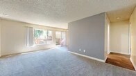 Located at 1175 W Blaine St in Riverside, California, this single-floor residence offers four bedrooms and one bathroom within a efficiently arranged floor plan. The layout flows from an entrance through a hallway connecting the home's key spaces.

The living room is a standout area, featuring plush carpeting, a textured ceiling, and a large window alongside a sliding glass door that opens to a balcony. This generous amount of natural light, combined with views of surrounding greenery, creates a bright and welcoming atmosphere. A neutral grey accent wall adds a modern touch to the space.

The galley-style kitchen is well-appointed with white cabinetry, dark granite countertops, a gas range, and wood-look vinyl flooring. Recessed lighting and ample cabinet storage contribute to its functional design.

The four bedrooms are carpeted and finished with neutral tones, each receiving natural light from individual windows. Several bedrooms include sliding-door closets with built-in rods and shelving. The primary bedroom offers a comfortable footprint suitable for standard furnishings.

The shared bathroom features wood-look vinyl flooring, a vanity with dark granite counters and white cabinetry, a wall mirror, and a combined shower and bathtub enclosure.