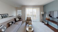 This two-story model unit at 1257 Armorlite in San Marcos showcases a well-designed layout with contemporary finishes throughout. The kitchen is a standout feature, equipped with rich espresso-toned cabinetry, sleek chrome hardware, white countertops, and black appliances including a range, built-in microwave, and full-size refrigerator. Warm hardwood-style flooring anchors the kitchen and bathrooms, creating a cohesive aesthetic.

The living area offers plush carpeting, an abundance of natural light, and sliding glass doors that open to a private balcony — perfect for enjoying outdoor views. A built-in cabinet with a white countertop in the entryway provides a welcoming and functional transition into the home.

Multiple bedrooms are spread across both floors. The primary bedroom features elevated ceilings, large windows, and soft carpeting, while additional bedrooms are equally well-appointed with ceiling fans and ample closet space. Two bathrooms mirror the kitchen's design sensibility, featuring espresso vanities, white countertops, and hardwood-style flooring — one with a tub/shower combination and the other a compact half-bath configuration. The overall ambiance is modern, clean, and move-in ready.