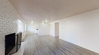 Located at 17840 32nd Avenue South in SeaTac, Washington, this single-floor residence offers a clean, functional layout designed for comfortable everyday living. The open living and dining area is finished with light-toned luxury vinyl plank flooring that runs throughout the main living spaces, creating a cohesive and easy-to-maintain environment. A standout feature of the living room is the white brick fireplace, which serves as a focal point and adds warmth and character to the space. Natural light enters through multiple windows fitted with blinds, and baseboard heating ensures year-round comfort.

The galley-style kitchen is efficiently designed with white cabinetry, dark granite-style countertops, a full suite of white appliances including a refrigerator, electric range, and dishwasher, and a stainless steel sink. A closet off the kitchen provides additional storage.

Two bedrooms are finished with plush wall-to-wall carpeting and feature windows that allow natural light in. Each room includes baseboard heating and offers ample space for furnishings. One bedroom connects directly to a full bathroom, which features a tiled tub and shower surround, a soaking tub, and a vanity with a dark countertop. The textured ceilings and neutral wall tones throughout contribute to a bright, clean overall aesthetic.