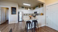 Located at 272 E 12300 S in Draper, Utah, this single-floor residence offers a thoughtfully designed layout that balances comfort and functionality. The open-concept kitchen is a standout feature, equipped with stainless steel appliances, granite countertops, crisp white cabinetry with ample storage, and a breakfast bar island with seating — ideal for both everyday meals and casual entertaining. Pendant lighting and decorative upper shelving add a refined touch to the space.

The living and dining areas flow naturally from the kitchen, featuring wood-style flooring, a ceiling fan, and large windows that invite natural light throughout. The living room provides a welcoming atmosphere with generous space for seating and relaxation.

Both bedrooms are well-sized, carpeted for comfort, and equipped with ceiling fans and windows with blinds. The primary bedroom offers a serene retreat with ample natural light, while the second bedroom is equally comfortable and versatile.

Two full bathrooms each include a tub/shower combination with tiled surrounds and wood-style flooring, providing a clean and functional design. A dedicated in-unit laundry room with a full-size washer and dryer and overhead shelving adds everyday convenience to this well-rounded Draper residence.