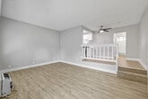 This 1-bedroom, 2-bathroom unit offers a thoughtfully designed layout across a single floor, making efficient use of its compact footprint. The living area is open and airy, featuring light wood-style vinyl plank flooring, neutral warm-gray walls, clean white baseboards, and a textured ceiling. A ceiling fan adds comfort overhead, while a staircase with a white-painted banister adds a distinctive architectural detail. A vertical wall-mounted heater and a window unit provide climate control throughout the space.

The galley-style kitchen is a standout feature, outfitted with white shaker cabinetry, brushed nickel hardware, white quartz countertops, a subway tile backsplash, and stainless steel appliances including a gas range and dishwasher. A skylight brings additional brightness into the kitchen.

The bedroom is carpeted and comfortably sized, featuring a mirrored sliding-door closet and a window with outdoor views. The two bathrooms are clean and functional, one including a full tub/shower combination with white tile surround and a window for natural light. A hallway with additional cabinetry and quartz counters provides extra storage and connects the rooms seamlessly. Overall, the space presents a clean, updated aesthetic throughout.
