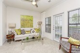 This single-floor residence offers a thoughtfully designed layout that balances comfort and functionality throughout its interconnected spaces. The living room serves as the heart of the home, featuring plush carpeting, multiple large windows dressed with sheer white curtains, and a glass-panel door that invites abundant natural light. A dedicated seating nook with access to outdoor views provides an ideal reading or relaxation corner.

The dining area is positioned adjacent to the living space and features crown molding, a window with garden views, and wainscoting detail along the walls, lending a refined character to the room.

The galley-style kitchen is outfitted with light wood cabinetry, white countertops, wood-look luxury vinyl plank flooring, and a full suite of stainless steel appliances including a range, microwave, refrigerator, and dishwasher. A dedicated closet off the kitchen conveniently houses an in-unit washer.

The primary bedroom offers carpeted floors, ample natural light from dual windows, and direct access to a walk-in closet. A second bedroom provides similar comfort with generous window coverage and built-in storage. The full bathroom features wood-look flooring, a tub-shower combination, a single vanity with white countertop, and wood-toned cabinetry.