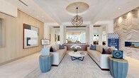 Located at 99 Wilkens Lane in Hyannis, MA, this elegantly appointed single-floor space offers a seamless blend of modern design and refined comfort. The expansive layout encompasses multiple living areas, a dining room, a full kitchen, and a connecting hallway, all unified by a cohesive contemporary aesthetic.

The primary living area features a striking coffered ceiling with a sculptural geometric pendant light as its centerpiece, flanked by two plush neutral sofas and a round marble coffee table. A built-in entertainment wall with light wood cabinetry, integrated shelving, and decorative tile accents anchors a secondary lounge area. Floor-to-ceiling windows flood the space with abundant natural light and provide open views of the surrounding greenery and outdoor courtyard.

The kitchen is outfitted with light wood cabinetry, dark countertops, stainless steel appliances, and a distinctive patterned tile backsplash, all set atop light hardwood flooring. A service counter with a stunning marble slab surface and herringbone tile backdrop adds an elevated touch.

The dining area showcases a live-edge wood table surrounded by mid-century modern chairs, set against a bold textured accent wall with brass sconce lighting. Tray ceilings and recessed lighting throughout contribute to the space's refined, layered ambiance.