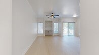 This well-designed two-bedroom, one-bathroom residence in Austin, TX offers a clean, modern aesthetic throughout its single-story layout. Light wood-style flooring flows consistently across the space, enhancing the bright and airy atmosphere created by abundant natural light from multiple windows and a sliding glass door.

The open living area is a standout feature, highlighted by crown molding, a ceiling fan, built-in shelving, and a sliding door that opens to outdoor views, filling the room with natural light. Adjacent to the living area, the kitchen impresses with white shaker cabinetry, quartz countertops, a subway tile backsplash, stainless steel appliances including a refrigerator, dishwasher, and range, plus a peninsula with a undermount sink — ideal for both cooking and casual dining.

The primary bedroom is generously sized and includes a ceiling fan and a walk-in closet with wire shelving for ample storage. The second bedroom also features a ceiling fan and a natural light-filled window. The bathroom is elegantly appointed with marble-style tile surrounding a soaking tub and shower, paired with a shaker-style vanity and matte black hardware accents. The entrance provides a welcoming transition into this thoughtfully finished Austin home.