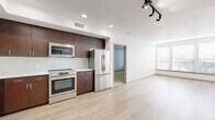 Located at 3111 S St, Unit 304 in Sacramento's 95816 zip code, this three-bedroom, two-bathroom unit offers a well-designed single-floor layout with a clean, modern aesthetic throughout. The open-concept kitchen and living area serves as the heart of the unit, featuring rich dark-wood cabinetry, white subway tile backsplash, stainless steel appliances including a dishwasher, range, microwave, and refrigerator, along with light wood-style flooring that extends through the main living space. Recessed and track lighting illuminate the kitchen and living areas, while windows provide natural light. The living room is generously proportioned, offering flexible furniture arrangements with a door providing additional light. The three bedrooms are carpeted and bright, each with white walls and windows fitted with blinds. The primary bedroom is a comfortable size and is accompanied by a walk-in closet outfitted with built-in shelving and hanging rods. The two bathrooms include a full bath with a soaking tub and shower combo, a toilet, and built-in shelving for storage, finished with light wood-style flooring. Two hallways connect the layout efficiently, and three closets in total provide abundant storage throughout the unit.