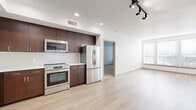 Located at 3111 S St, Unit 304 in Sacramento's 95816 zip code, this three-bedroom, two-bathroom unit offers a well-designed single-floor layout with a clean, modern aesthetic throughout. The open-concept kitchen and living area serves as the heart of the unit, featuring rich dark-wood cabinetry, white subway tile backsplash, stainless steel appliances including a dishwasher, range, microwave, and refrigerator, along with light wood-style flooring that extends through the main living space. Recessed and track lighting illuminate the kitchen and living areas, while windows provide natural light. The living room is generously proportioned, offering flexible furniture arrangements with a door providing additional light. The three bedrooms are carpeted and bright, each with white walls and windows fitted with blinds. The primary bedroom is a comfortable size and is accompanied by a walk-in closet outfitted with built-in shelving and hanging rods. The two bathrooms include a full bath with a soaking tub and shower combo, a toilet, and built-in shelving for storage, finished with light wood-style flooring. Two hallways connect the layout efficiently, and three closets in total provide abundant storage throughout the unit.