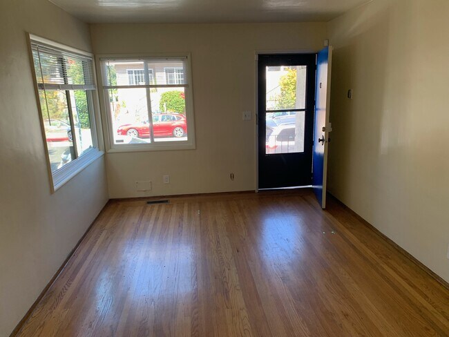 The living room is flooded with natural light, hardwood floor and fresh coatt of paint - 485A Clifton St