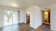 This single-floor residence at 25 Bishop Terrace in Stratford, New Jersey, offers a practical and well-organized layout across several distinct living areas. The living space transitions between plush carpeting and durable hardwood-style flooring, creating clear visual separation between zones. A sliding glass door floods the main living area with natural light and provides direct access to a private outdoor balcony, offering views of the surrounding greenery.

The kitchen is equipped with stainless steel appliances, including a full-size refrigerator and an electric range with a ventilation hood. Warm honey-toned cabinetry pairs with dark granite-style countertops, providing ample storage and workspace. A sink with additional counter space rounds out the functional layout.

The bedrooms are carpeted and generously proportioned, each featuring windows that allow natural light to filter in. Closet access is provided within the bedroom corridor, adding practical storage options. The bathroom features large-format tile flooring, a tub-shower combination with decorative mosaic tile accents, a white vanity, and clean, neutral finishes throughout.

Overall, the unit presents a clean, neutral palette with white walls and consistent trim work, offering a move-in ready environment that is both functional and comfortable.