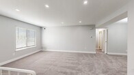 Located at 800 Trenton Rd in Langhorne, PA, this well-appointed single-floor unit offers a clean, modern aesthetic throughout its thoughtfully designed layout. The kitchen is a standout space, featuring dark shaker-style cabinetry, light quartz countertops, a subtle glass tile backsplash, and a full suite of stainless steel appliances including a gas range, dishwasher, microwave, and refrigerator. Light wood-look flooring grounds the kitchen with a contemporary feel. The living areas and bedrooms are finished with plush neutral carpeting and painted in soft grey tones, creating a calm and cohesive atmosphere. Multiple bedrooms offer natural light through slatted blinds, and at least one features a dedicated walk-in closet with built-in shelving, while another is accented by an elegant multi-bulb chandelier. A spacious open lower-level area includes a decorative white metal stair railing and access to additional storage. The bathroom is finished with large-format marble-look wall tiles surrounding a soaking tub and shower combination, complemented by grey floor tiles. Recessed lighting throughout adds a polished touch to every room.