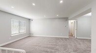 Located at 800 Trenton Rd in Langhorne, PA, this well-appointed single-floor unit offers a clean, modern aesthetic throughout its thoughtfully designed layout. The kitchen is a standout space, featuring dark shaker-style cabinetry, light quartz countertops, a subtle glass tile backsplash, and a full suite of stainless steel appliances including a gas range, dishwasher, microwave, and refrigerator. Light wood-look flooring grounds the kitchen with a contemporary feel. The living areas and bedrooms are finished with plush neutral carpeting and painted in soft grey tones, creating a calm and cohesive atmosphere. Multiple bedrooms offer natural light through slatted blinds, and at least one features a dedicated walk-in closet with built-in shelving, while another is accented by an elegant multi-bulb chandelier. A spacious open lower-level area includes a decorative white metal stair railing and access to additional storage. The bathroom is finished with large-format marble-look wall tiles surrounding a soaking tub and shower combination, complemented by grey floor tiles. Recessed lighting throughout adds a polished touch to every room.