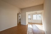 Located at 18 Dalton Ct in Redlands, CA, this single-story unit offers a well-organized layout with a comfortable flow between living, dining, and sleeping areas. The main living space features warm hardwood-style flooring and opens into a dining area equipped with a ceiling fan and large vertical-blind-covered window that filters generous natural light. Tall ceilings in portions of the living area contribute a sense of openness throughout.

The kitchen is outfitted with white cabinetry, granite-style countertops, a gas range, built-in microwave, dishwasher, and a double basin sink positioned beneath a window. Recessed lighting in the tray ceiling adds a refined touch to the functional workspace.

The bedrooms are carpeted for comfort, each benefiting from notable natural light. One bedroom features a large picture window with outdoor views, while another includes a sliding glass door opening to a private patio and a built-in closet with shelving. A second sliding glass door in the living area also provides direct outdoor access, extending the living space further.

Two bathrooms serve the unit—one with a full tub-shower combination and hardwood-style flooring, the other a convenient half bath. Neutral tones and textured ceilings are consistent throughout, lending the space a clean, cohesive aesthetic.