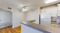 Located at 990 Pacific Hills Point in Colorado Springs, CO, this one-bedroom, one-bathroom residence offers a well-planned single-level layout designed for comfortable everyday living. The open-concept living and kitchen area serves as the heart of the home, where warm hardwood-style flooring flows throughout. A ceiling fan with integrated lighting keeps the space comfortable year-round. The kitchen features a wraparound peninsula with granite-style countertops, white cabinetry, and full-size appliances including a refrigerator and microwave, providing ample prep and storage space. A sliding glass door in the living room fills the space with natural light and opens to an outdoor area. The bedroom is a comfortable retreat finished with plush carpeting and a large window that brings in additional natural light. A dedicated closet provides organized storage. The bathroom is clean and functional, offering a full tub-shower combination with tiled surround, a vanity with white cabinetry, and hardwood-style flooring. A separate laundry room houses a full-size washer and dryer, adding everyday convenience. The overall aesthetic is bright and neutral throughout.