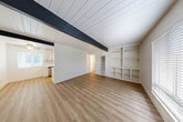 Located at 3329 Claremont Ct in Santa Rosa, CA, this single-story, 3-bedroom, 1-bathroom home delivers a clean, modern aesthetic with thoughtful architectural character throughout. The open living area immediately impresses with a striking white shiplap ceiling accented by bold, dark exposed beams that run the length of the room. Light wood-tone laminate flooring flows consistently through the home, creating a warm and cohesive feel. A standout feature of the living room is the floor-to-ceiling built-in shelving unit, offering generous display and storage space. Natural light filters in through windows fitted with blinds, brightening the crisp white walls.

The galley-style kitchen is well-appointed with white shaker cabinets, quartz countertops, black hardware, stainless steel appliances including a dishwasher and range, and a dedicated dining nook with a ceiling fan and window. The bathroom features elegant marble-look tile surrounding the tub and shower with gold-tone fixtures, adding a refined touch.

The bedrooms are bright and airy, each benefiting from the same vaulted shiplap ceilings and exposed beams. The primary bedroom includes a sliding-door closet, while additional closets are distributed throughout. A central hallway connects all rooms efficiently, completing this well-designed and move-in ready home.