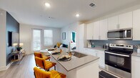 Located at 72 Milton Ave SE in Atlanta's Grant Park area, this modern single-floor residence offers a well-designed open-concept layout with clean contemporary finishes. The kitchen is a standout feature, equipped with stainless steel appliances including a refrigerator, range, microwave, and dishwasher, complemented by crisp white cabinetry, a blue-gray tile backsplash, quartz countertops, and light wood-style flooring. A large central island with an integrated sink provides generous prep space and doubles as a dining area with stylish seating. The open layout seamlessly connects the kitchen to the living and dining areas, which are bathed in natural light from large windows. The primary bedroom is spacious and bright, featuring multiple windows with outdoor views, plush carpeting, and a ceiling fan. Its en-suite bathroom offers a dual-sink vanity with quartz countertops, a glass-enclosed shower, light wood-style flooring, and access to a walk-in closet. A second bedroom also features plush carpeting and ample natural light. An additional bathroom includes a vanity with storage and light wood-style flooring. Recessed lighting throughout enhances the home's bright, modern ambiance.