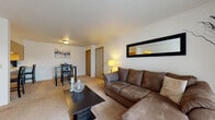 Located at 217 Northcrest Dr in Angola, Indiana, this single-floor unit offers a practical and comfortable layout across several well-defined living spaces. The living room is a welcoming area featuring wall-to-wall carpet, a large sliding glass door with vertical blinds that invites natural light and provides outdoor views, and a baseboard heating system. A wall-mounted mirror adds depth to the space. Adjacent to the living room, the dining area connects seamlessly to the kitchen through a pass-through counter, making the space feel open and cohesive. The galley-style kitchen is efficiently designed with ample white cabinetry trimmed in warm wood tones, full appliances including a range, refrigerator, dishwasher, and microwave, along with a double-basin sink. The primary bedroom features plush carpet, a ceiling fan with light fixture, and a window for natural light. A second bedroom offers dual closets with bi-fold wood doors and a window, making it well-suited as a bedroom or home office. The full bathroom includes a vanity with storage cabinetry, a sink with mirror, a toilet, and a shower-tub combination. Throughout the unit, neutral tones and carpeted floors create a clean, functional living environment.