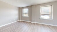 Located at 233 W Broadway in Louisville, Kentucky, this efficient single-floor unit offers a thoughtfully laid-out living space designed for comfortable everyday living. The layout includes a living room, a closet, and a full bathroom, making practical use of every square foot.

The living room serves as the heart of the unit, finished with light wood-style luxury vinyl flooring that runs throughout the space, lending a clean and contemporary feel. Warm greige-toned walls complement the crisp white baseboards and trim, creating a neutral palette that is both modern and inviting. Multiple windows allow ample natural light to fill the room, brightening the interior and offering views of the surrounding urban streetscape. A textured ceiling adds a subtle architectural detail overhead.

The entry area features a solid paneled door with a deadbolt, along with a louvered closet door providing convenient storage access. The bathroom is outfitted with a full-size soaking tub and shower combo, complete with chrome fixtures, a toilet, and a towel ring, all set against the same cohesive neutral tones found throughout the unit.

Overall, this space presents a clean, move-in-ready environment with consistent finishes and a functional floor plan well-suited for urban living in downtown Louisville.