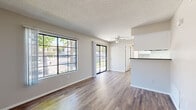 Located at 450 N Soldano Ave in Azusa, California, this single-floor, 2-bedroom, 3-bathroom residence offers a functional and well-appointed layout. Throughout the home, rich wood-look flooring provides a warm, cohesive aesthetic that ties each room together.

The open living and dining area is bright and inviting, featuring large grid-pane windows that allow abundant natural light and views of the surrounding greenery. A ceiling fan adds comfort, while a sliding glass door leads directly to the patio, seamlessly extending the living space outdoors.

The galley-style kitchen is efficiently designed with white cabinetry, dark countertops, a double sink, a dishwasher, and a black electric range with overhead ventilation. A half-wall peninsula separates the kitchen from the dining area, offering a convenient pass-through feel.

Both bedrooms are well-sized, with the primary bedroom offering a notably generous footprint, large grid-pane windows with outdoor views, and access to a dedicated closet. Each bedroom benefits from ample natural light and a neutral color palette. The three bathrooms include a full bath with a soaking tub and shower combination. Two closets provide practical storage throughout the home. Textured ceilings are present throughout, adding a classic residential character to the space.