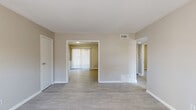 Located at 3248 Chamblee Dunwoody Rd in Chamblee, GA, this single-story home offers three bedrooms, one bathroom, and four closets across a well-organized floor plan. The interior features a consistent neutral color palette with warm beige walls and crisp white trim throughout, creating a clean and cohesive aesthetic.

The living areas are finished with light wood-style flooring that extends through the main spaces, while the bedrooms feature plush carpeting for added comfort. Each bedroom is generously proportioned with windows fitted with horizontal blinds that allow natural light to filter in. The spacious primary bedroom offers notable room to accommodate a full furniture arrangement.

The kitchen is equipped with white shaker-style upper cabinets, light granite-look countertops, a decorative tile backsplash with a diamond accent pattern, and black appliances including a range, dishwasher, and refrigerator. Light wood-style flooring continues here, complementing the bright cabinetry.

The bathroom includes a full tub-shower combination with white tile surround and a window that brings in natural light. A central hallway connects the main rooms efficiently. With four closets distributed throughout, storage is a practical highlight of this home's layout.