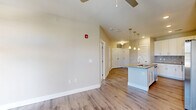 Located at 523 S Madison Ave in Greenwood, Indiana, this thoughtfully designed one-bedroom, one-bathroom residence offers a well-appointed single-floor layout. The open-concept living and kitchen area serves as the heart of the home, featuring light-toned luxury vinyl plank flooring, recessed lighting, and a ceiling fan that enhances airflow and comfort. The kitchen is a standout feature, showcasing crisp white shaker cabinetry, a neutral tile backsplash, quartz-style countertops, and a full suite of stainless steel appliances including a range, microwave, and refrigerator. A central island with a built-in sink and elegant pendant lighting provides additional prep space and serves as a natural gathering point. The living area benefits from multiple windows that bring in natural light and offer views of the surrounding neighborhood. The spacious bedroom is finished with plush carpeting, dual windows, and a ceiling fan, while two closets — including a walk-in style — offer generous storage. The bathroom features wood-look tile flooring, a white vanity with a framed mirror, and a glass-enclosed shower. A dedicated laundry area adds everyday convenience, completing this clean, modern residence.