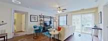 This contemporary 850 square foot apartment in Blacksburg, VA, offers a well-designed living space with two bedrooms and two bathrooms. The open floor plan maximizes space efficiency, creating a seamless flow between the kitchen, living room, and dining area. The kitchen boasts light wood cabinetry, modern appliances, and a convenient breakfast bar with seating for two.

The living room features hardwood flooring, a ceiling fan, and large windows that flood the space with natural light. A sliding glass door leads to an outdoor area, extending the living space. The room is furnished with a comfortable sofa and a stylish entertainment unit with open shelving.

Both bedrooms are well-appointed, with the primary bedroom measuring 140 square feet. They feature plush carpeting, ceiling fans, and large windows with blinds for privacy. The bathrooms are functional and modern, with one showcasing a wooden vanity and a shower/tub combination.

Throughout the apartment, neutral wall colors provide a blank canvas for personalization, while carefully chosen artwork and decor add pops of color and visual interest. The overall design strikes a balance between contemporary style and cozy comfort, making it an ideal home for urban living.