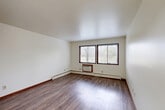 Located at 1005 Gilbert Rd in Madison, WI, this 2-bedroom, 1-bathroom unit offers a practical and well-organized single-floor layout. The open-concept living, dining, and kitchen area forms the heart of the home, providing a versatile space for both everyday living and entertaining. The kitchen is equipped with white cabinetry extending to the ceiling for generous storage, a full-size refrigerator, an electric range, a sink, and neutral countertops. Track lighting and wood-look laminate flooring complete the kitchen's clean, functional aesthetic.

The living area is bright and airy, featuring two large windows that invite natural light and offer views of surrounding greenery. Baseboard heating and a wall-mounted AC unit are present throughout the unit for year-round comfort. Both bedrooms continue the wood-look flooring and feature windows with blinds, baseboard heaters, and neutral white walls. The spacious primary bedroom benefits from dual windows, while the second bedroom offers a comfortable and well-proportioned layout. Three closets throughout the unit provide ample storage.

The full bathroom includes a single-sink vanity with white cabinetry, a toilet, and tile flooring. A hallway connects all rooms, contributing to a logical and efficient flow throughout the home.