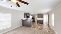 Located in Fort Pierce, Florida, this single-floor, 3-bedroom, 2-bathroom home offers a well-designed layout with a comfortable and functional flow throughout. The open-concept living, dining, and kitchen area serves as the heart of the home, featuring wood-look flooring, crown molding, and a ceiling fan that enhances the bright, airy atmosphere. Natural light filters in through white-shuttered windows, adding warmth to the neutral-toned walls.

The kitchen is well-appointed with rich dark cabinetry, light granite-style countertops, a kitchen island with a beadboard panel, a double basin sink, and black stainless appliances including a range, dishwasher, microwave, and refrigerator. Additional cabinet storage extends into the dining area.

All three bedrooms are carpeted and finished with crown molding, each featuring windows that bring in natural light. The primary bedroom is a comfortable size with closet access. Four closets throughout the home provide generous storage.

The two bathrooms are finished with the same wood-look flooring and dark cabinetry with granite-style countertops. One bathroom features a full tub-shower combo, while the other offers a sink and toilet. A dedicated laundry room completes this practical and well-appointed home.