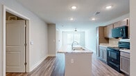 Located at 4311 Shoppers Lane in Columbus, Ohio, this single-floor residence offers a thoughtfully designed layout that maximizes every square foot. Consistent wood-look flooring flows throughout the entire space, creating a cohesive and modern aesthetic complemented by neutral gray walls and crisp white trim.

The combined kitchen and living area forms the heart of the home. The kitchen is well-appointed with rich, two-toned cabinetry, light granite countertops, a kitchen island, and a full suite of black Whirlpool appliances including a refrigerator, electric range, and over-the-range microwave. The adjacent living room is bright and airy, featuring a ceiling fan with light fixture and double windows that invite natural light and offer views of the surrounding neighborhood.

The bedroom is a comfortable retreat with multiple windows fitted with blinds, providing both natural light and privacy. A dedicated closet offers convenient storage. The full bathroom features a vanity with granite-style countertop, a large wall mirror, and warm cabinetry that ties in with the kitchen's design language. The clean, open layout of the bathroom reflects the same modern simplicity found throughout the home, making this residence a practical and attractive option in the Columbus area.