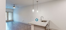 This contemporary 700 square foot apartment offers a well-designed living space with a single bedroom and bathroom. The kitchen is a standout feature, boasting modern gray cabinetry, stainless steel appliances, and a stylish backsplash. A central island with a granite countertop provides additional prep space and casual dining options.

The bedroom, measuring 170 square feet, is generously sized for the apartment's overall footprint. It features a large window for natural light and is equipped with a modern ceiling fan. Adjacent to the bedroom, a walk-in closet offers ample storage with multiple shelving units.

Throughout the apartment, wood-look flooring adds warmth and continuity. The bathroom showcases a contemporary design with a combined tub and shower, surrounded by sleek tiling. Recessed lighting and pendant fixtures in the kitchen contribute to the modern ambiance.

The efficient layout maximizes the available space, with a hallway connecting the various rooms. French doors in one area suggest access to a balcony or patio, extending the living space outdoors. Overall, this apartment combines modern aesthetics with practical design, ideal for those seeking a compact yet comfortable living environment.
