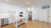 Located at 497 N McDowell Blvd in Petaluma, CA, this thoughtfully designed 2-bedroom, 1-bathroom home offers a clean, modern aesthetic throughout its generously sized single-floor layout. Light wood-tone flooring flows seamlessly across all rooms, creating a warm and cohesive feel.

The heart of the home is the open-concept kitchen, which impresses with floor-to-ceiling white shaker cabinetry, a classic white subway tile backsplash, and a full suite of stainless steel appliances including a French door refrigerator, electric range, over-the-range microwave, and dishwasher. A central white island provides additional prep and dining space, while recessed lighting keeps the area bright and functional.

The living area extends naturally from the kitchen in an open-plan arrangement, offering flexibility for various furniture configurations. Both bedrooms are well-proportioned, featuring light-filled windows with blinds and ceiling fans for added comfort. The primary bedroom includes ample closet space.

The bathroom is finished in a crisp, modern style with white cabinetry, a quartz countertop vanity with brushed nickel fixtures, a framed mirror, and a full tub-shower combination. A private balcony adds outdoor living potential, rounding out this well-appointed Petaluma home.