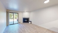 Located in Shoreline, WA, this well-appointed 1-bedroom, 1-bathroom unit offers a thoughtfully designed layout with clean, modern finishes throughout. Light wood-style flooring runs seamlessly across the entire space, lending warmth and continuity to every room.

The open living area is a welcoming focal point, centered around a sleek, tile-framed electric fireplace and illuminated by recessed lighting. A pass-through window connects the living room to the kitchen, creating an open and airy feel. The galley-style kitchen is efficiently designed with two-tone cabinetry — white upper cabinets paired with gray lower cabinets — complemented by light countertops, black hardware accents, stainless steel appliances, and track lighting overhead.

The bedroom is generously sized, featuring a large double sliding-door closet, a window allowing natural light, and a baseboard heating unit. The bathroom continues the modern aesthetic with a gray vanity, white countertop, bold black-framed mirror, black fixtures, and a well-lit vanity bar above.

A hallway connects the main living spaces, providing a practical flow through the unit. The overall ambiance is clean, bright, and contemporary, making this a comfortable and stylish space in the Shoreline community.