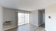 Located at 5925 El Cajon Boulevard in San Diego, unit #201 is a second-floor residence that combines clean, modern design with comfortable, functional living spaces. The unit is situated on a single floor, offering a seamless and accessible layout throughout.

The living area is a standout feature of this unit, showcasing smooth hardwood-style flooring that adds warmth and a contemporary feel to the space. A full-width sliding glass door with vertical blinds fills the room with abundant natural light while providing direct access to a private balcony, offering pleasant outdoor views of the surrounding neighborhood. The neutral gray wall tones complement the light-toned floors, creating a bright and airy atmosphere.

The textured ceiling adds a classic architectural detail throughout the space, while clean white baseboards provide a crisp finishing touch. The open layout of the living area allows for flexible furniture arrangements, making it easy to personalize the space.

Overall, unit #201 at 5925 El Cajon presents a well-maintained, light-filled residence with thoughtful finishes, practical design, and a welcoming ambiance well-suited for comfortable everyday living in the heart of San Diego.