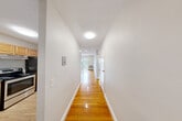 Located at 725 Adams St in Boston's Dorchester neighborhood, this 2-bedroom, 1-bathroom unit offers a clean, functional layout across a single floor. A well-lit entrance hallway with warm hardwood flooring connects the main living areas, setting a bright and welcoming tone throughout. The kitchen features white cabinetry, a stainless steel refrigerator, a dishwasher, and a granite-style countertop with sink, complemented by durable wood-look flooring. Two living areas provide flexible space for dining, lounging, or a home office setup. The primary bedroom is a generously sized retreat with rich hardwood floors, a baseboard heating system, and natural light from a window, along with two closets for ample storage. The second bedroom also features hardwood floors, baseboard heat, and its own closet. The full bathroom is finished with white tile flooring, a shower/tub combo, a vanity with sink, and a multi-bulb light fixture. With six closets total distributed throughout the unit, storage is plentiful. Neutral wall tones and clean white trim create a bright, move-in-ready atmosphere throughout this well-maintained Boston home.