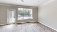 Located in Kennesaw, GA, this three-story home offers a well-organized layout spread across multiple levels. The entry level includes an attached garage with an automatic opener, providing convenient, private parking and additional storage space. The main living floor features an open-concept kitchen and living room, where rich dark-stained cabinetry contrasts beautifully with crisp white subway tile backsplash and light countertops. Stainless steel appliances, including a range and refrigerator, complement the kitchen's peninsula, which offers extra prep space and a natural flow into the living area. Wood-look flooring, crown molding, and large windows with abundant natural light and outdoor views define the living space, which also provides access to a balcony. The upper floor hosts both bedrooms, each featuring plush carpeting, ceiling fans, and windows that bring in natural light. The primary bedroom is generously sized and includes a walk-in closet with wire shelving for organized storage. The two full bathrooms include a tub-shower combination with clean white tile surrounds. A hallway connects the upper-level rooms, completing this efficiently designed multi-story home.