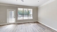 Located in Kennesaw, GA, this three-story home offers a well-organized layout spread across multiple levels. The entry level includes an attached garage with an automatic opener, providing convenient, private parking and additional storage space. The main living floor features an open-concept kitchen and living room, where rich dark-stained cabinetry contrasts beautifully with crisp white subway tile backsplash and light countertops. Stainless steel appliances, including a range and refrigerator, complement the kitchen's peninsula, which offers extra prep space and a natural flow into the living area. Wood-look flooring, crown molding, and large windows with abundant natural light and outdoor views define the living space, which also provides access to a balcony. The upper floor hosts both bedrooms, each featuring plush carpeting, ceiling fans, and windows that bring in natural light. The primary bedroom is generously sized and includes a walk-in closet with wire shelving for organized storage. The two full bathrooms include a tub-shower combination with clean white tile surrounds. A hallway connects the upper-level rooms, completing this efficiently designed multi-story home.