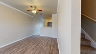 This two-story home offers a thoughtfully designed layout spread across two floors, providing comfortable living for everyday needs. The main level features a generous living room finished with durable wood-look flooring, crown molding, and a ceiling fan, creating a bright and welcoming atmosphere. Adjacent to the living room, the galley-style kitchen is well-equipped with dark cabinetry, light countertops, tile flooring, and black appliances including a gas range and refrigerator, alongside ample counter and storage space. A staircase connects the main level to the upper floor, where three carpeted bedrooms are located. The primary bedroom includes a walk-in closet and a ceiling fan, while the additional bedrooms also feature closets and ceiling fans. The two bathrooms are finished consistently with dark cabinetry, light countertops, and wood-look flooring, with one featuring a tub-shower combination. Three closets throughout the home provide generous storage. Completing the layout is a two-car garage with an automatic opener, offering secure and convenient parking. The home's consistent use of neutral tones, wood-look flooring, and dark cabinetry accents creates a cohesive and functional aesthetic throughout.
