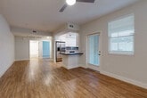 Located at 12406 Clark St in Moreno Valley, CA, this well-designed 1-bedroom, 1-bathroom home offers a thoughtful layout across a single floor. The open-concept living and dining area is bright and welcoming, featuring warm hardwood-style flooring, neutral walls, and a ceiling fan overhead. Large windows with blinds invite natural light throughout, while a door provides direct access to a private balcony. The kitchen is a standout feature, showcasing white shaker cabinetry, dark countertops, a gray subway tile backsplash, and a full suite of stainless steel appliances including a refrigerator, gas range, microwave, and dishwasher. A peninsula counter adds additional prep and dining space. The bedroom offers a comfortable retreat with plush carpet flooring, a window with natural light, and access to a dedicated closet. The bathroom is clean and functional, featuring white cabinetry with a dark countertop, a full bathtub/shower combo, and matching hardwood-style flooring. A separate laundry area adds everyday convenience. The entry foyer provides a clean transition into the main living space. Overall, the home presents a modern, move-in-ready aesthetic with consistent finishes throughout.