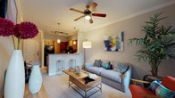 Located in Dunwoody, GA, this single-floor residence offers a thoughtfully designed layout that balances comfort and functionality. The open-concept living area is bright and inviting, featuring plush carpeting, crown molding, and a ceiling fan with a light fixture. Large windows with floor-to-ceiling drapes allow natural light to fill the space, while a glass door provides access to a private balcony with exterior views. The living room comfortably accommodates a seating area and an entertainment setup, with a wall-mounted television and a wooden media console adding warmth to the space.

The kitchen is well-equipped with rich wood cabinetry, a tile backsplash, and a full suite of black appliances, including a refrigerator, range, and dishwasher. A breakfast bar with seating connects the kitchen to the living area, creating a seamless flow ideal for entertaining. Pendant lighting and track lighting illuminate the space effectively.

The bedroom is a serene retreat, featuring soft carpeting, ample natural light from a large window with elegant dark drapes, and neutral tones throughout. The full bathroom offers a spacious vanity with wood cabinetry, light countertops, tile flooring, and a tub-shower combination, delivering a clean, functional design.