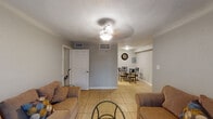 Located at 6425 S Gessner Rd in Houston, Texas, this single-floor unit offers a practical and well-organized layout designed for comfortable everyday living. The living room serves as the central gathering space, finished with light ceramic tile flooring, neutral gray walls, and a ceiling fan with light fixture. A sliding glass door floods the room with natural light and provides access to an outdoor area, enhancing the open feel of the space. The living room flows seamlessly into a dedicated dining area, which is adjacent to the kitchen and features a compact dining set beneath a wall clock accent. The kitchen is efficiently designed with dark gray cabinetry, speckled countertops, a double-basin stainless steel sink, and black appliances including a range and refrigerator. Ample upper and lower cabinet storage makes the kitchen highly functional. The bedrooms are comfortably sized, each featuring tile flooring, ceiling fans, and closet access, providing restful and practical private retreats. The bathroom is clean and well-appointed, with a vanity featuring dark cabinetry, a tub-shower combination, and tile flooring. Throughout the unit, consistent tile flooring, textured ceilings, and neutral tones create a cohesive and low-maintenance interior aesthetic.