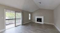 Located at 3200 Oakwood Village Ln in Chamblee, Georgia, this well-appointed single-floor residence offers a thoughtful layout paired with modern finishes throughout. The living room serves as the heart of the home, showcasing soaring vaulted ceilings with a textured finish, a white-surround fireplace as a focal point, and durable wood-look flooring. Sliding glass doors flood the space with natural light and open directly onto a private balcony overlooking a canopy of mature trees and the surrounding neighborhood. The kitchen is efficiently designed with white shaker cabinetry, granite-look countertops, stainless steel appliances including a refrigerator, range, microwave, and dishwasher, and a skylight that brightens the space. The bedrooms feature wood-look flooring and generous storage, with one room offering multiple built-in closets with louvered bifold doors. Two full bathrooms are finished with granite-look vanity countertops, white cabinetry, and tile-look flooring; one includes a shower-tub combo. The private balcony provides a serene outdoor retreat with views of lush greenery. Neutral tones and clean finishes create a cohesive, move-in ready ambiance throughout the home.