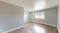 Located at 1707 Lincoln Ave in Norwood, Ohio, this well-appointed one-bedroom unit offers a clean, modern aesthetic with thoughtful finishes throughout its single-floor layout. The open living area is bright and welcoming, featuring light-toned vinyl plank flooring and neutral gray walls that create a calm, versatile backdrop. A partial dividing wall separates the living space from the compact kitchen, which is equipped with white cabinetry and white appliances, including a refrigerator and stove. The kitchen flows efficiently within a dedicated nook, maximizing the use of available space. The bedroom is a comfortable, private retreat with the same consistent flooring and gray wall palette. It features a large sliding-door closet offering ample storage, along with an additional door providing further access. Windows in the bedroom allow natural light to filter in, giving the room an airy feel. Baseboard heating units are present throughout the unit, ensuring warmth during cooler months. White trim and baseboards add a crisp, finished look that ties the space together. The overall ambiance is clean, neutral, and move-in ready, reflecting a freshly updated interior that balances simplicity with functional design — well-suited for comfortable everyday living in the Norwood community.
