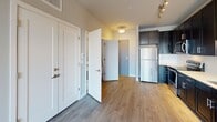 Located at 20 W Northwest Hwy in Mount Prospect, IL, this contemporary single-floor unit offers a well-designed layout with modern finishes throughout. The open-concept kitchen is a standout feature, outfitted with dark espresso cabinetry, crisp white countertops, a classic subway tile backsplash, and a full suite of stainless steel appliances including a refrigerator, range, microwave, and dishwasher. The kitchen flows seamlessly into the main living area, which is finished with warm hardwood-style flooring that extends throughout the common spaces, creating a cohesive and inviting atmosphere. A sliding glass door opens to a private balcony, allowing natural light to fill the space while offering views of the surrounding neighborhood. The bedroom features plush carpeting and large windows with exterior views, providing a comfortable and quiet retreat. The bathroom is appointed with dark cabinetry and white countertops, and is complemented by a dedicated walk-in closet with built-in wire shelving for ample storage. Additional closet space and in-unit storage further enhance the functionality of this well-planned residence. The unit's neutral color palette and clean architectural lines contribute to a modern, move-in-ready aesthetic.