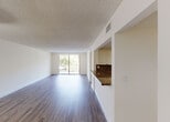 Located at 18335 NW 68 Ave in Hialeah, FL, this single-floor residence offers a clean, modern interior with a cohesive design throughout. Wood-look flooring flows seamlessly across every room, complemented by crisp white walls and textured ceilings that add subtle character to each space.

The open living area is bright and spacious, benefiting from natural light that pours in through a large sliding glass door leading to a private balcony with views of the surrounding greenery. Adjacent to the living area, the kitchen is well-appointed with rich granite countertops, cream-toned cabinetry, recessed lighting, and a full suite of white appliances including a range, microwave, dishwasher, and refrigerator.

The bedrooms are generously sized, each featuring windows that invite natural light and outdoor views. One bedroom includes access to a walk-in closet, providing ample storage. The bathrooms are thoughtfully finished — one features a tiled shower-tub combination with white cabinetry and granite vanity, while the second showcases a glass-enclosed walk-in shower with decorative tile accents, a granite-topped vanity, and tile flooring.

Overall, the space presents a well-maintained, move-in-ready interior with consistent finishes and a bright, airy ambiance throughout.