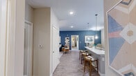Located at 105 Exchange Circle in Asheville, NC, this well-appointed two-bedroom, two-bathroom residence offers a thoughtfully designed single-floor layout with a comfortable sense of space throughout. The living room serves as the heart of the home, featuring a ceiling fan, neutral tones, and French doors that open to a private balcony, flooding the space with natural light and providing outdoor access. An accent wall adds depth and character to the room.

Adjacent to the living area, the dining nook provides an intimate setting framed by warm-toned walls and art-ready wall space. The galley-style kitchen is equipped with dark espresso cabinetry, granite-look countertops, a subway tile backsplash, and black appliances, offering both style and functionality. Light wood-tone flooring runs through the kitchen and wet areas.

The spacious primary bedroom features plush carpet, natural light from large windows, and a ceiling fan, complemented by a generously sized walk-in closet with wire shelving on multiple walls. The second bedroom is equally comfortable, also with carpet and ample window light. Both bathrooms are finished with dark wood vanities, light countertops, and wood-look flooring. A dedicated laundry room with side-by-side washer and dryer and overhead shelving completes this well-rounded residence.