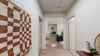 Located at 700 Berkeley Place Cir in Clemson, SC, this spacious 6-bedroom, 4-bathroom single-floor unit offers a well-designed layout ideal for shared living. Light wood-style flooring flows throughout the main areas, while soft carpet adds comfort to each bedroom.

The combined kitchen and living room serves as the heart of the unit. The kitchen features dark wood cabinetry, stainless steel appliances, a pendant light fixture, and direct access to an in-unit washer and dryer. A compact dining area with a bar-height table sits adjacent to the kitchen. The living room is bright and welcoming, with a ceiling fan, large windows, and a glass door that allows generous natural light.

Three hallways connect the six bedrooms efficiently across the floor plan. Each bedroom is carpeted and includes a closet, with select rooms featuring built-in desks and shelving — practical touches well-suited for students. The primary bedroom offers a comfortable footprint with natural light from a window.

The four bathrooms are finished with light wood-style flooring, white fixtures, shower-tub combinations, and dark wood vanities with white countertops. Clean, neutral walls are consistent throughout the unit, creating a cohesive and functional living environment in the heart of Clemson.