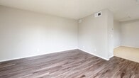 Located at 1256 W Arrow Hwy in Upland, California, this single-floor unit offers a practical and well-organized layout. The open-concept living, dining, and kitchen areas flow seamlessly together, creating an efficient and welcoming living environment. Wood-style vinyl flooring runs throughout the main areas, adding warmth and a modern aesthetic, while a textured ceiling provides a classic residential feel.

The kitchen is thoughtfully designed with white upper and lower cabinetry offering ample storage, light-toned countertops, a peninsula with a built-in sink ideal for casual dining or meal prep, and white appliances including a refrigerator, electric range, and microwave. A window above the sink allows natural light to brighten the space. A skylight-style ceiling fixture further enhances visibility.

The living area is bright and airy, benefiting from a sliding glass door that opens to an outdoor patio area, inviting natural light and providing views of greenery. The space includes two closets for storage. The bathroom is clean and functional, featuring a full tub-shower combination with white surround, a toilet, and wood-style flooring that ties cohesively to the rest of the unit. Central air and heating vents are present throughout, ensuring year-round comfort.