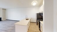 Located at 13801 Paramount Blvd in Paramount, CA, this 2-bedroom, 1-bathroom residence offers a well-organized single-floor layout designed for comfortable everyday living. Light wood-style flooring runs throughout the entire unit, creating a clean, cohesive aesthetic that ties each room together.

The open-concept living and kitchen area serves as the heart of the home. The living room features a ceiling fan, a built-in fireplace flanked by a tall built-in bookshelf, and a sliding glass door with vertical blinds that invite natural light. The kitchen is outfitted with white cabinetry, a peninsula with a deep single-basin sink and a modern pull-down faucet, stainless steel appliances including a gas range, microwave, and refrigerator, and ample counter space.

The spacious primary bedroom offers generous square footage and receives natural light through a large window with horizontal blinds overlooking the surrounding neighborhood. The second bedroom is bright and functional, featuring the same light flooring and clean white walls. A dedicated closet provides additional storage.

The bathroom is finished with a full tub-shower combination with a curved curtain rod, tile flooring, and white walls that maintain the unit's light and neutral palette throughout.