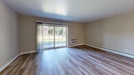 Located at 300 Glen Meadow Road in Franklin, MA, this 2-bedroom, 1-bathroom residence offers a thoughtfully arranged single-floor layout finished with modern, consistent hardwood-style flooring throughout. The living room is a bright and welcoming space, highlighted by a large sliding glass door that floods the room with natural light and provides views of the surrounding greenery. A wall unit and baseboard heating ensure year-round comfort. The kitchen is well-appointed with crisp white shaker cabinetry, a grey countertop, a subway tile backsplash, and a full suite of stainless steel appliances, including a refrigerator, range, microwave, and dishwasher. The primary bedroom is generously proportioned, featuring three windows that invite ample natural light, baseboard heating, and a wall unit. It is complemented by a built-in closet. The second bedroom also includes a window, baseboard heating, and a closet. The bathroom is elegantly finished with a marble-patterned tub and shower surround, light tile flooring, and clean white fixtures. A connecting hallway ties all rooms together, completing this well-organized and neatly updated residence.