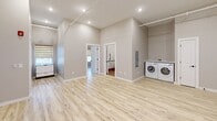 Located at 612 Hazard Ave in Enfield, CT, this thoughtfully designed two-bedroom, one-bathroom unit offers a clean, modern aesthetic across a single floor. Light-toned luxury vinyl plank flooring flows throughout, lending a bright and cohesive feel to the entire space. The kitchen is a standout feature, showcasing bold royal blue cabinetry paired with white subway tile backsplash, white countertops, and a full suite of stainless steel appliances including a refrigerator, dishwasher, wall oven, and microwave. A wall-mounted mini-split system provides efficient climate control. The open living area benefits from recessed lighting and vaulted ceilings, creating an airy atmosphere. A washer and dryer are conveniently located within the unit. The primary bedroom features dual windows with zebra blinds that allow for adjustable natural light, along with a wall-mounted mini-split unit. Bedrooms are equipped with double-door closets accented by matte black hardware. The bathroom is a well-appointed space highlighted by floor-to-ceiling marble-look tile, a walk-in roll-in shower with a built-in bench and handheld fixture, wood-look tile flooring, and a wall-mounted sink with matte black fixtures — reflecting an accessibility-conscious design throughout.